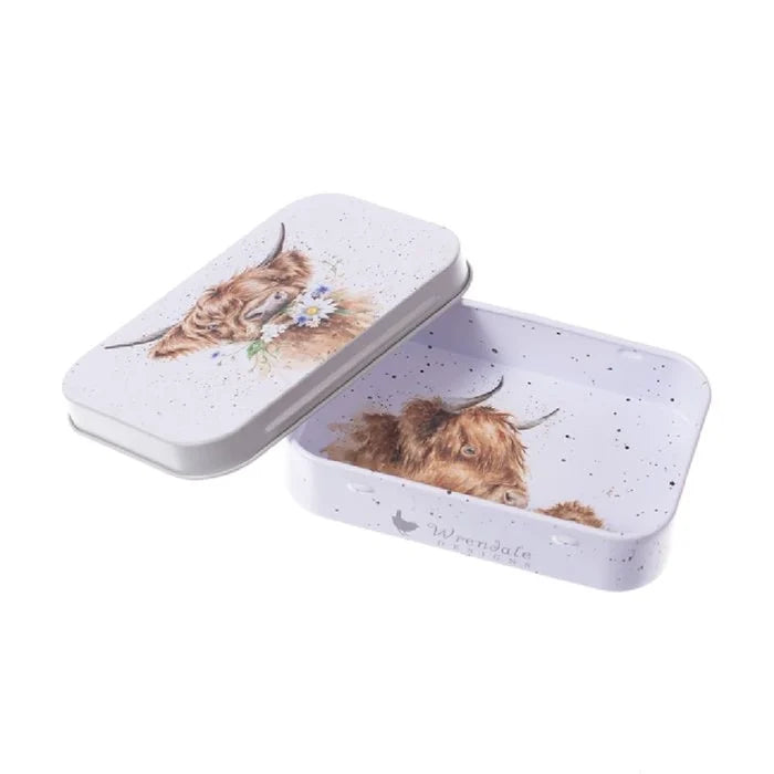 A tin box featuring a decorative cow design on its surface.