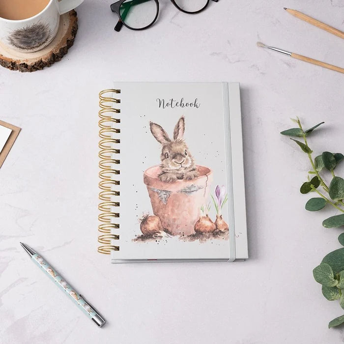 Wrendale Designs 'The Flower Pot' rabbit spiral bound notebook on desk with mug, pen, and greenery – countryside-inspired stationery gift.