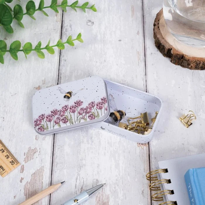 A decorative tin adorned with a bee and floral patterns, emphasizing a whimsical, nature-themed aesthetic.