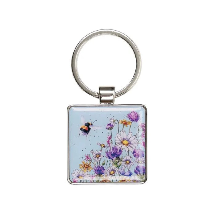 A square keychain displaying a bee and floral elements, emphasizing a nature-inspired theme.