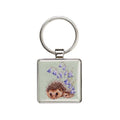 A square keychain featuring a hedgehog surrounded by delicate bluebells.