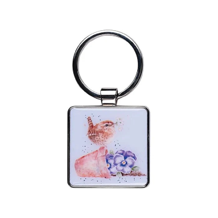 A square keychain featuring a colorful painting of a bird surrounded by vibrant flowers.