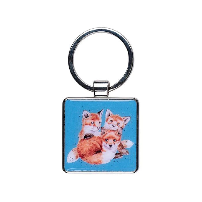 A keychain adorned with two charming fox figures, showcasing their distinct colors and playful expressions.