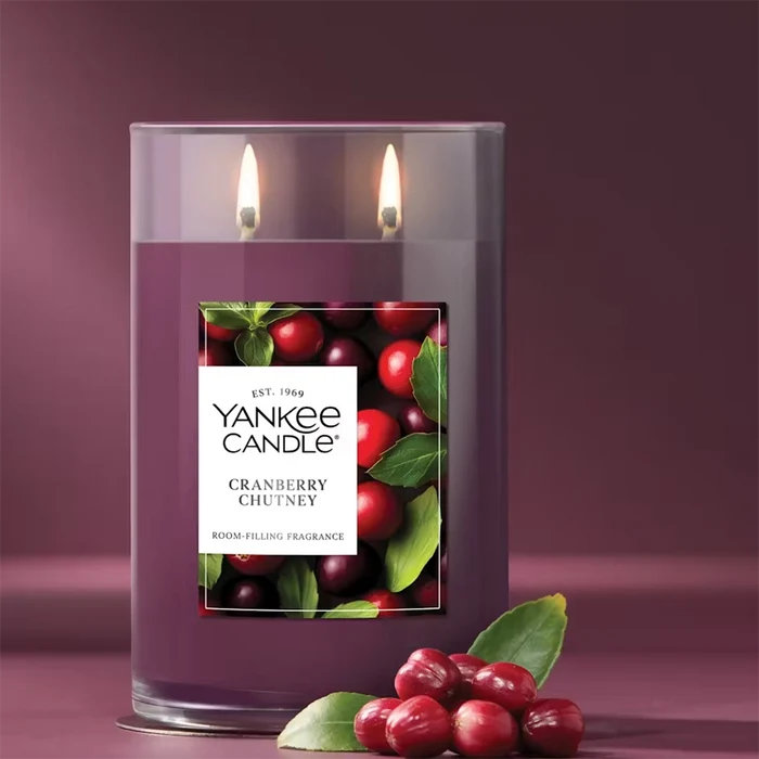 Yankee Candle cranberry chutney candle with cranberries and leaves on a purple background