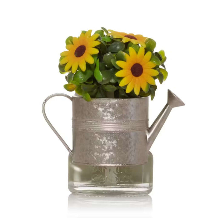 Decorative  fragrance diffuser shaped like a watering can  with sunflowers on a white background.