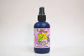Bottle of organic ylang ylang hydrosol with a pink label on a white background