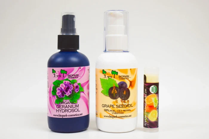 Three bottles of organic skincare products on a white background